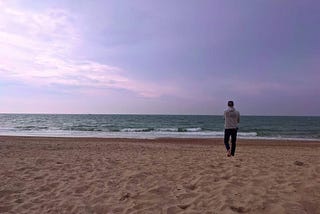 Lloyd on a sandy beach looking out to sea