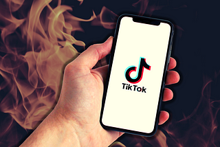 A hand holding a phone with the tiktok app opened