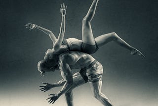 A man balancing a woman on his back as a dance pose