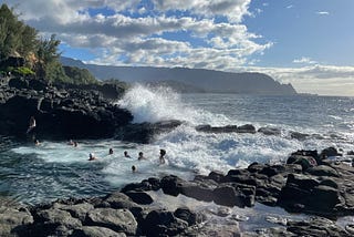 Queen’s Bath in Kaua’i, Hawaii. Crashing waves against a unique tide pool surrounded by igeneous rock, off the Pacific Ocean.