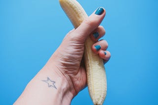 hand holding an unpeeled banana