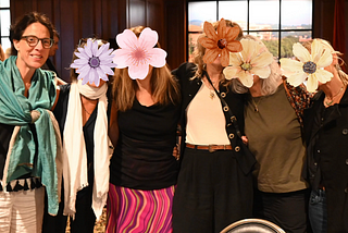 Six Women, five faces covered with flower graphic