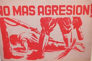 Post-card with a drawing of a man lying down and soldier’s boots around him. It says in the title: “No more agression”