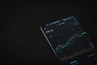 Phone with ETH stockchart up on a black background