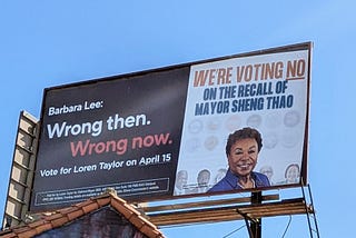 Billboard with a photo of former Congresswoman Barbara Lee. The text above her head reads We’re voting NO on the recall of Mayor Sheng Thao. The text on the left side reads Barbara Lee: Wrong then. Wrong now. Vote for Loren Taylor on April 15.