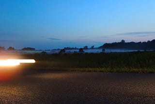 car headlights blurred on a dark country road.