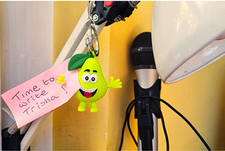 A pear shaped key ring character with a hand-written not stuck to it -’Time to write Trisha’.