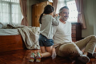 Color photo of daughter styling her father’s hair.