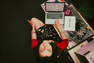 a young woman, the author, sits at a desk smiling