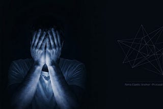 A man sitting in total darkness, covering his face with his hands, illuminated by a deep blue light.