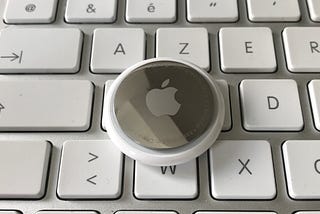 Apple Airtag placed on an Apple wireless keyboard.