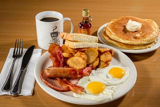 big breakfast with coffee and hotcakes eggs and hash browns