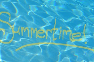 Aqua-colored swimming pool water with the word “Summertime!” written in yellow