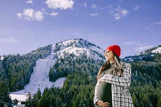 Holding my 8 month pregnant belly at Crystal Mountain