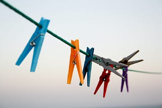 A clothesline with colorful pegs.