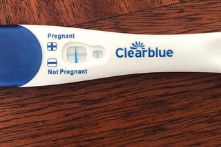 A Clear Blue pregnancy test showing a blue cross, indicating pregnancy.