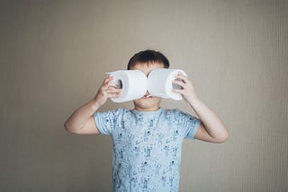 Boy, looking through toilet paper rolls as thought they are binoculars