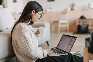 women sitting in front of her laptop writing