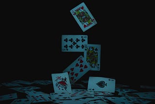 Imagem de cartas de baralho caindo do ar sobre um fundo escuro