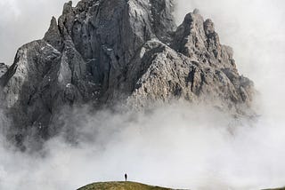 A hiker ready for a treacherous hike through a cloudy mountain, which represents the journey through their own mind.