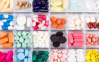 The best California Designated Representative online training courses for: Drug/Device Wholesalers | 3PL (third-party logistics providers). Image of a medication pillbox full of brightly colored pills and tablets.