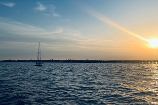 A sailboat sitting in the water at sunset in New Bern, North Carolina