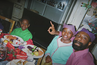 A black family enjoying Christmas dinner together.