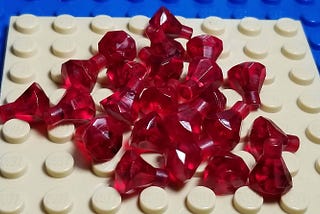 White and blue Lego pieces with some ruby pins
