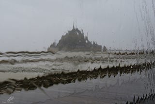 An image of Mont Saint Michael through a rainy window