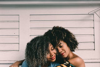 Two female friends hugging each other (https://unsplash.com/@holliver)