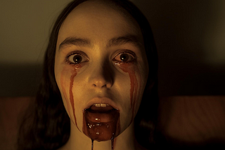 A young, beautiful woman has blood coming from her eyes and open mouth. Robert Eggers’ Nosferatu, Dracula, Nosferatu critic review, cinema, movie, horror, is Nosferatu a good film? What is, vampire, Depp, movie review, 2024