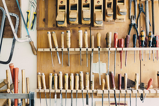 Photo of a wall of a workshop with handheld tools.