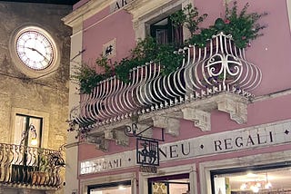 Image of a clock face in a beautiful Italian village. A privileged environment where billionaires buy expensive watches. Photo by Belcairn (author)