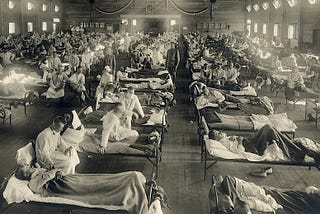 Sick soldiers laying in beds being attended by nurses