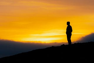 Silhouette of a man against a sunset backdrop.