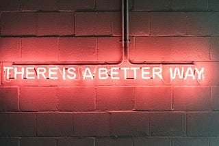 A neon sign that says “There Is A Better Way””