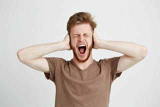 Man with hands over his ears shouting