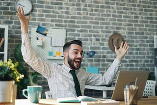 Photo by Vitaly Gariev: https://www.pexels.com/photo/office-worker-looking-at-the-screen-of-his-laptop-and-raising-his-arms-in-joy-22046235/