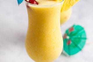 Pina colada cocktail with cherries and paper umbrellas
