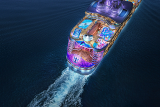 Image shows aerial view of Utopia of the Seas cruise ship from Royal Caribbean sailing across the ocean at night