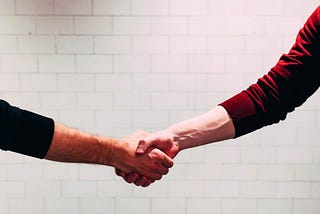 Handshake in front of white brick background