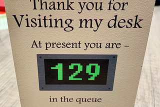 a sign that reads Thank you for visiting my desk, at present you are 129 in the queue