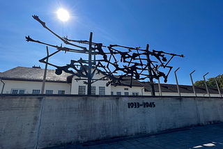 sculpture of people on a pole inside Dachau camp