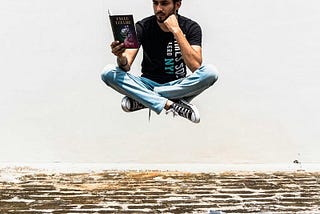 A young man reading a book, levitating off the ground