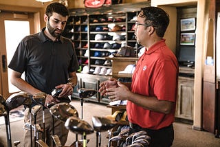two males standing in a golf store