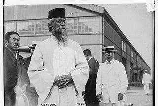 Bengali poet Rabindranath Tagore visits Japan, 1916. He is seen in the foreground, behind him there are other men, two facing the camera.