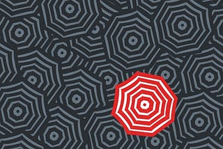 A red and white open umbrella in a sea of gray open umbrellas