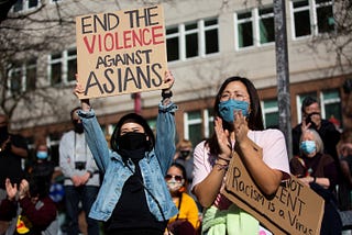 Dawn Cheung and Victoria Do clap and cheer while listening to speakers during a protest against anti-Asian hate crimes at Hing Hay Park in the Chinatown-International District of Seattle, Washington, March 13, 2021.