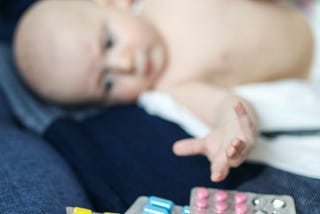 Sick baby reaches for medication