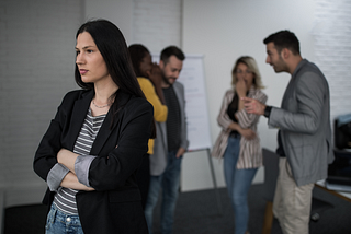 a woman looking annoyed while people gossip behind her back